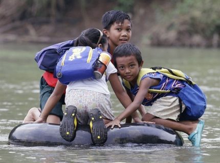 Elementary School Students Crossing A River On Inflated Tire Tubes, Rizal Province, Philippines