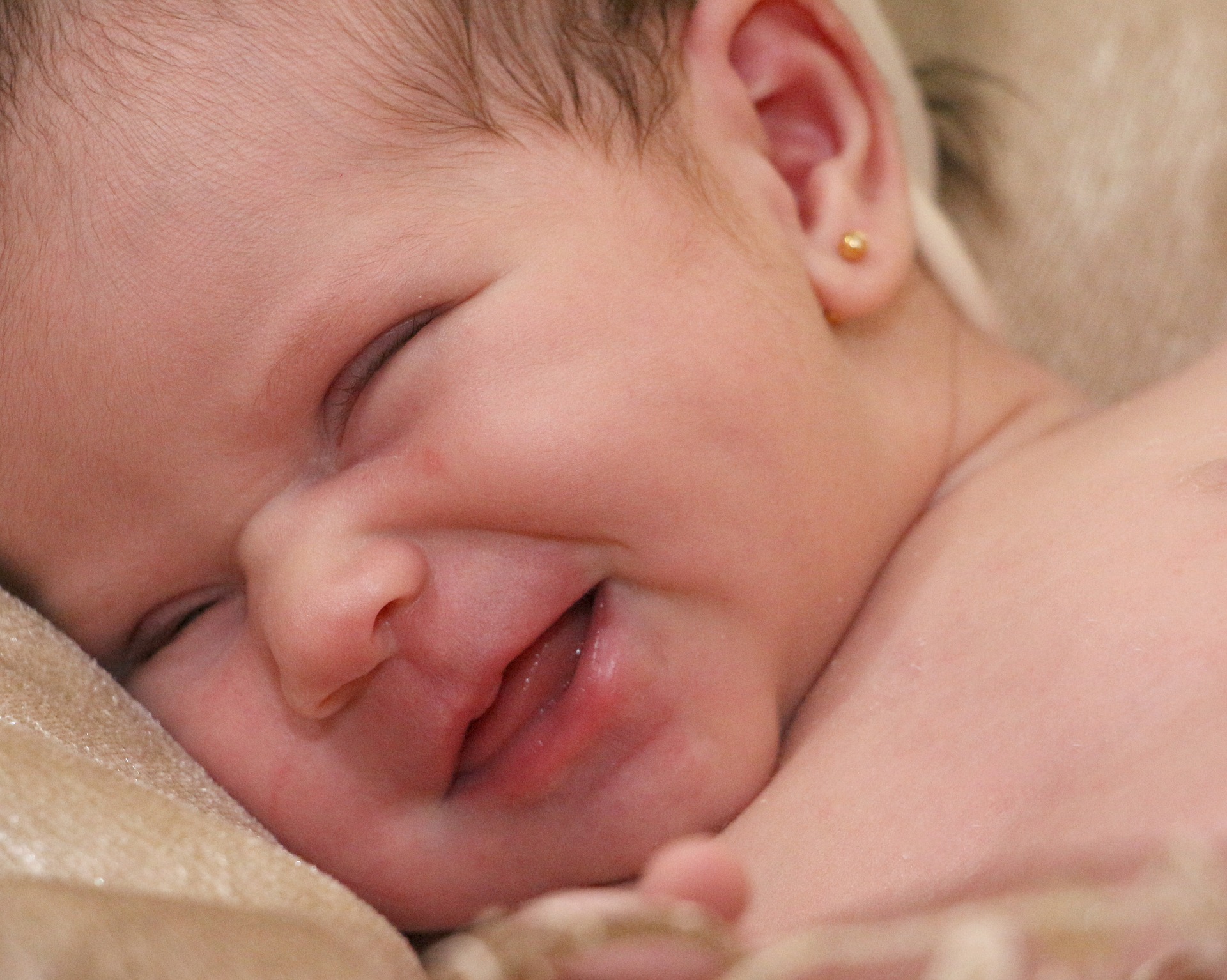 Первая улыбка ребенка. Новорожденный малыш улыбается. Первая улыбка младенца. Новорожденные детки улыбка. Младенец улыбается рождения.
